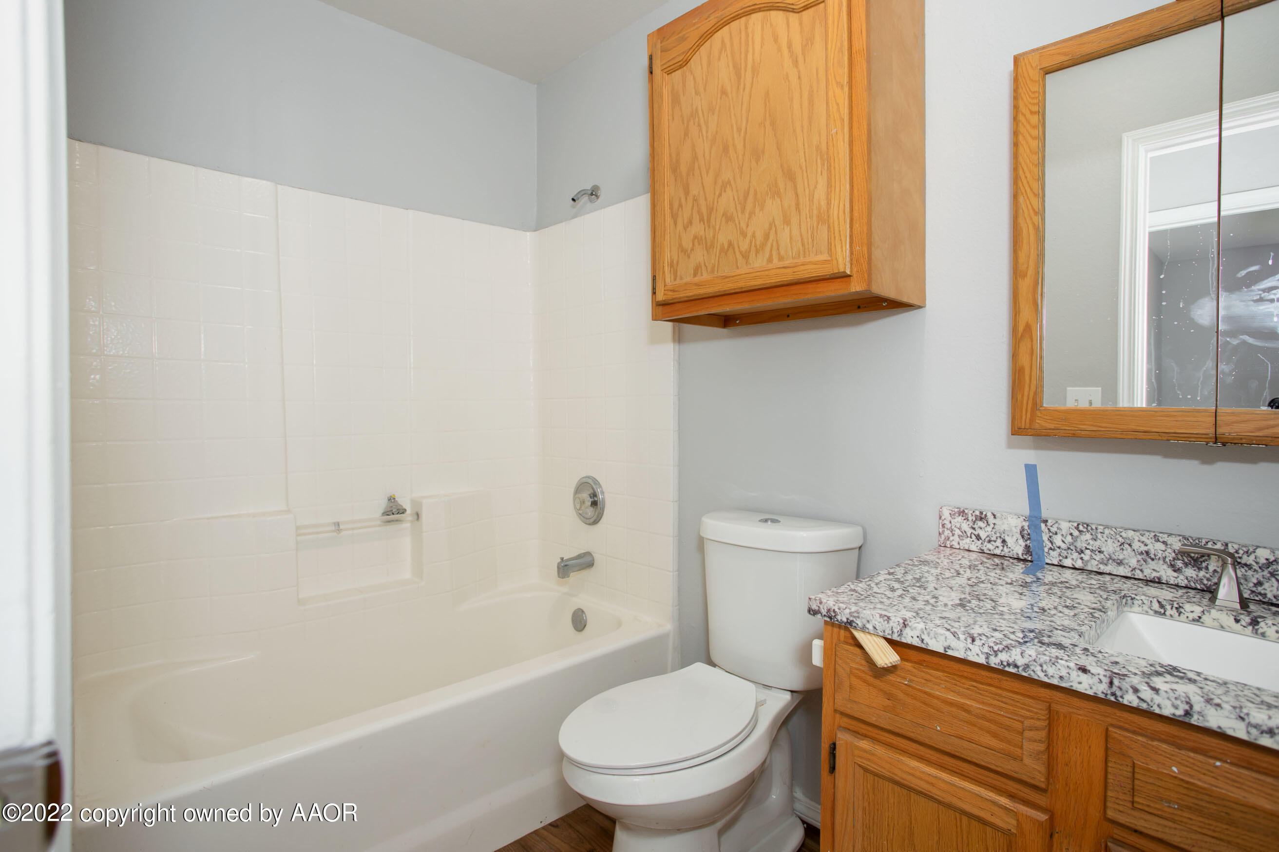 3808 Ross Street Amarillo, TX 79118 - Photo 7 of 22 a bathroom with a granite countertop toilet a sink and a mirror