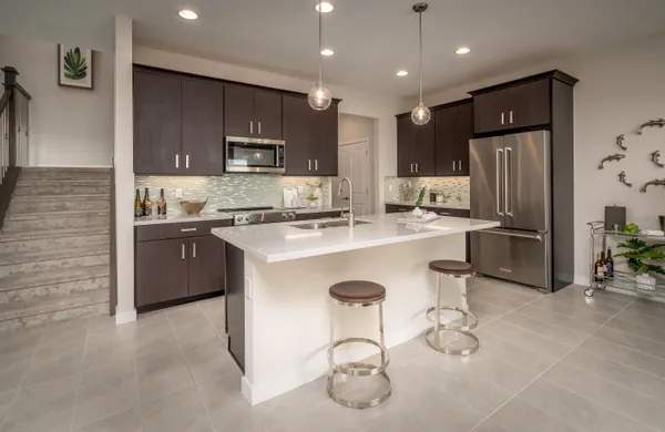 a kitchen with stainless steel appliances granite countertop a sink refrigerator and cabinets