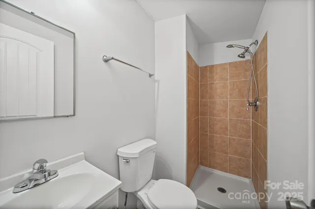 a bathroom with a sink mirror shower and toilet