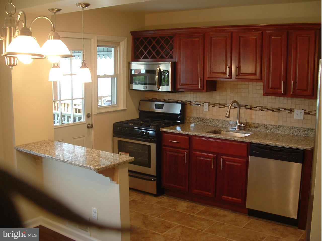 338 Torner Road Baltimore, MD 21221 - Photo 3 of 30 a kitchen with granite countertop wooden cabinets and a stove top oven