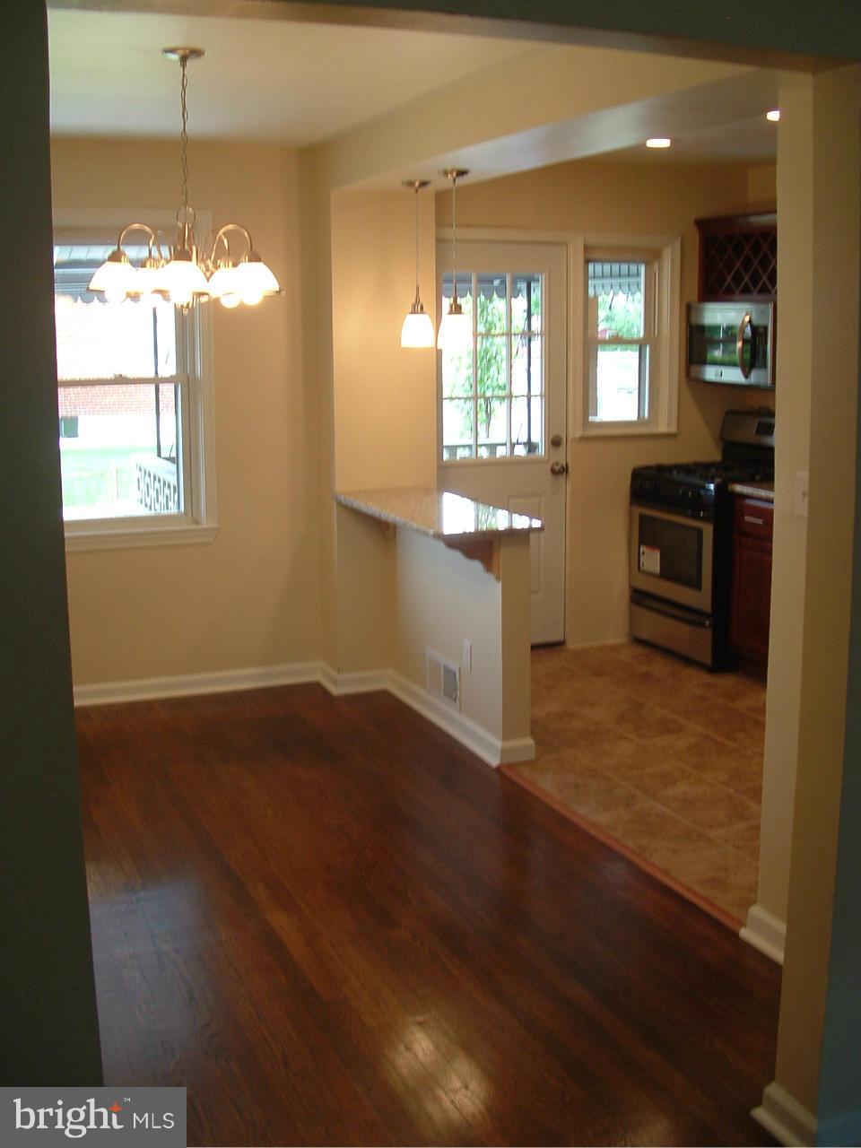 338 Torner Road Baltimore, MD 21221 - Photo 7 of 30 a kitchen with kitchen island granite countertop wooden floors and wide window