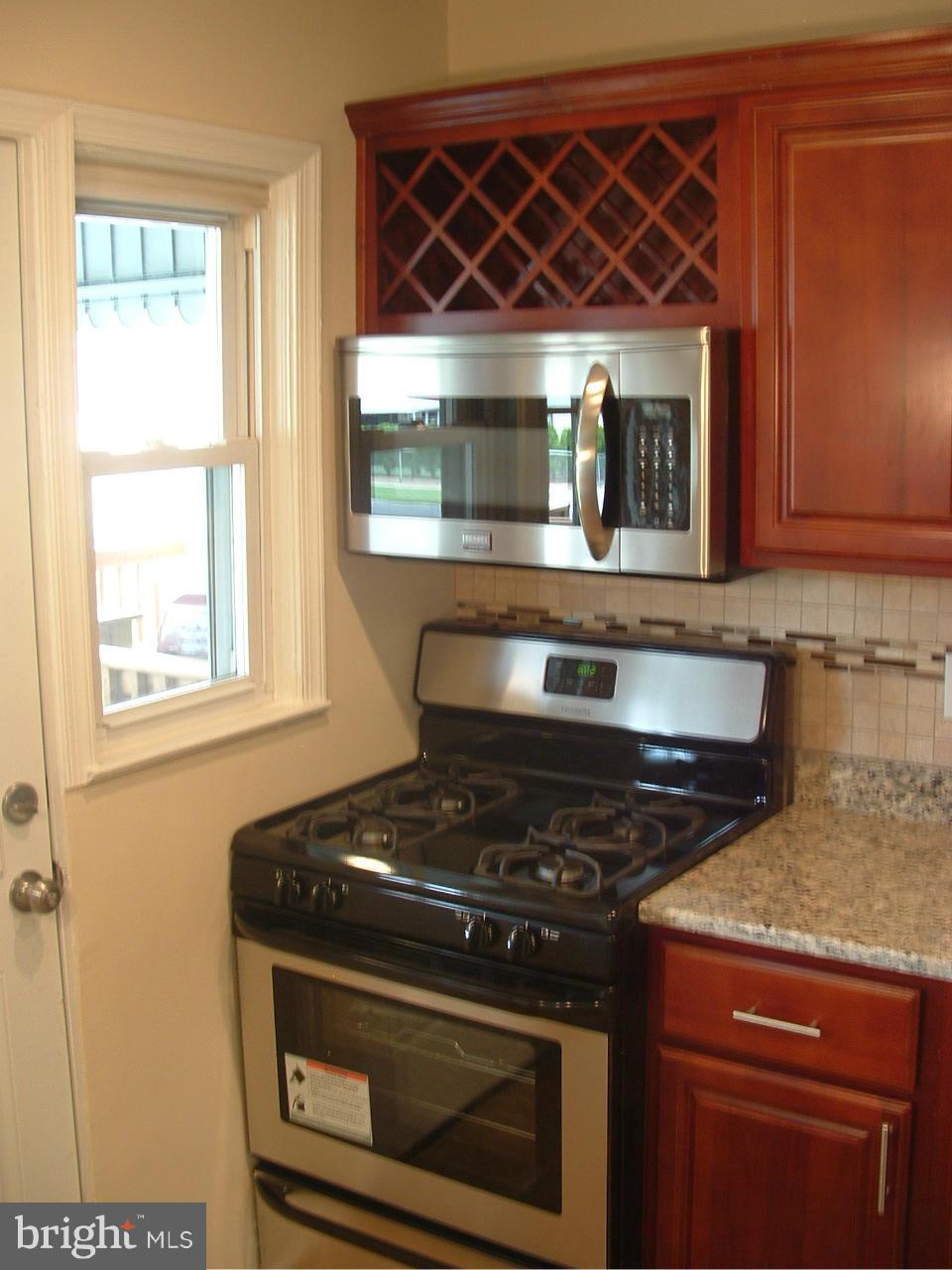 338 Torner Road Baltimore, MD 21221 - Photo 10 of 30 a kitchen with wooden cabinets and a stove top oven