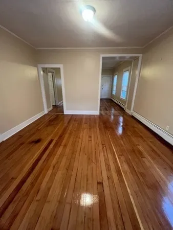 a view of empty room with wooden floor