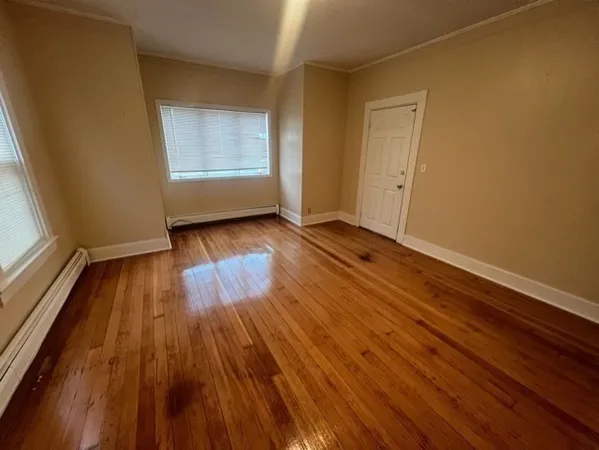 a view of a room with wooden floor and window