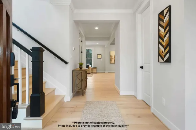 a view of a hallway with wooden floor and staircase