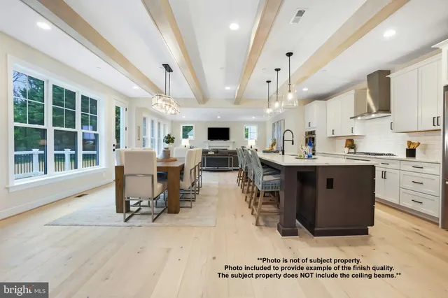 a dining hall with stainless steel appliances kitchen island granite countertop a table chairs and a large window