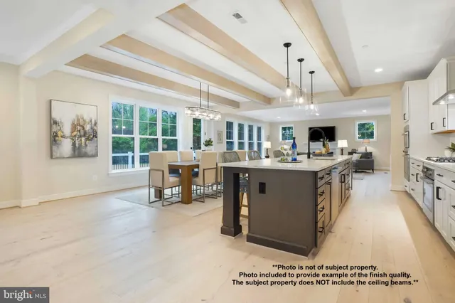 a living room with stainless steel appliances kitchen island granite countertop a table chairs and a view of kitchen