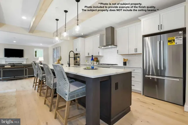 a kitchen with stainless steel appliances granite countertop a table chairs refrigerator and microwave