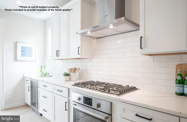 a kitchen with granite countertop a sink stove and cabinets