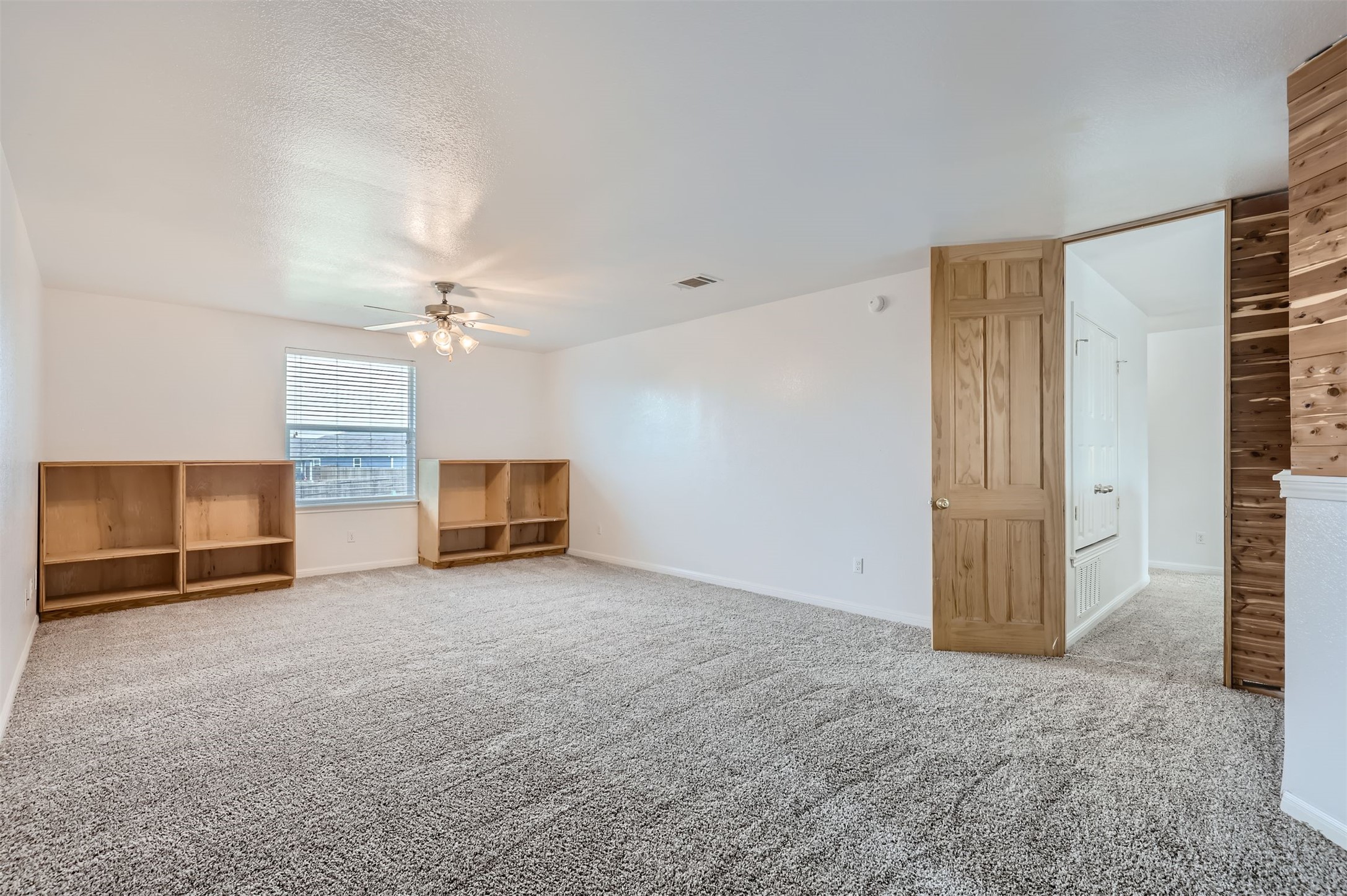 131 Lavaca Loop Hutto, TX 78634 - Photo 14 of 29 Well-lit and spacious bonus room, featuring plush carpeting and a practical ceiling fan for comfort.