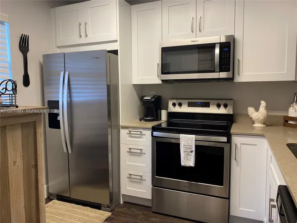a kitchen with stainless steel appliances a stove a microwave and cabinets