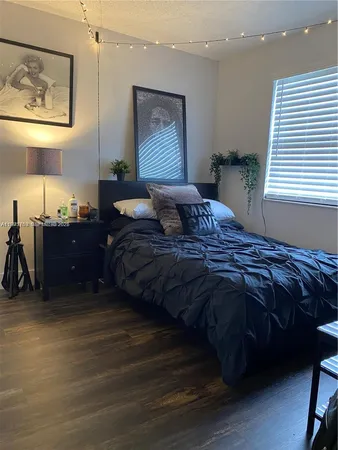 a bedroom with a bed and a lamp on dresser