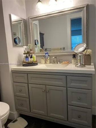 a bathroom with a toilet sink and mirror