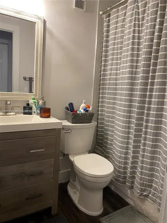 a bathroom with a toilet a sink and mirror