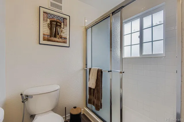 a bathroom with a toilet and a shower