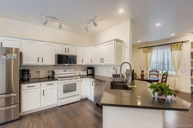a kitchen with white cabinets and white appliances