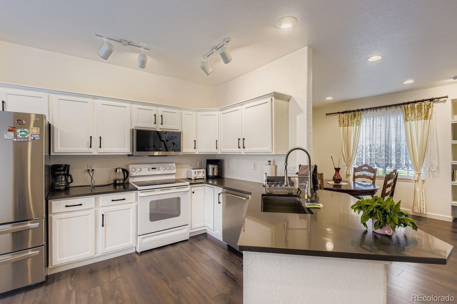 Undisclosed Address Aurora, CO 80013 - Photo 6 of 20 a kitchen with white cabinets and white appliances