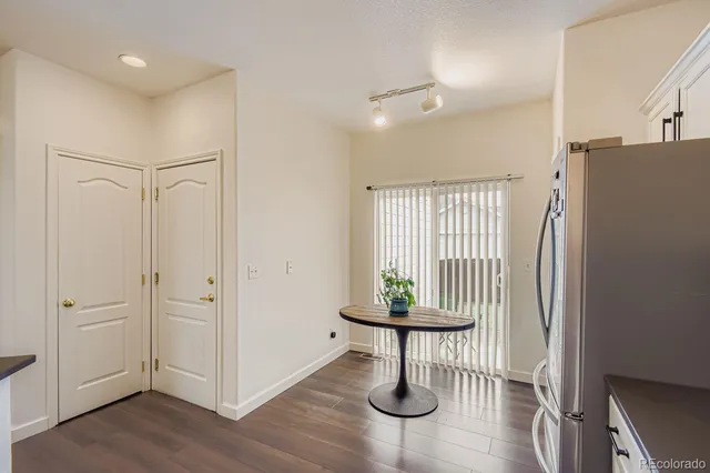 a view of entryway with kitchen and hall with wooden floor
