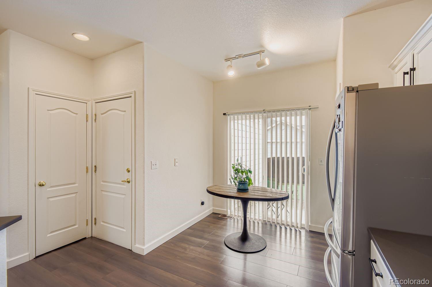 Undisclosed Address Aurora, CO 80013 - Photo 8 of 20 a view of entryway with kitchen and hall with wooden floor
