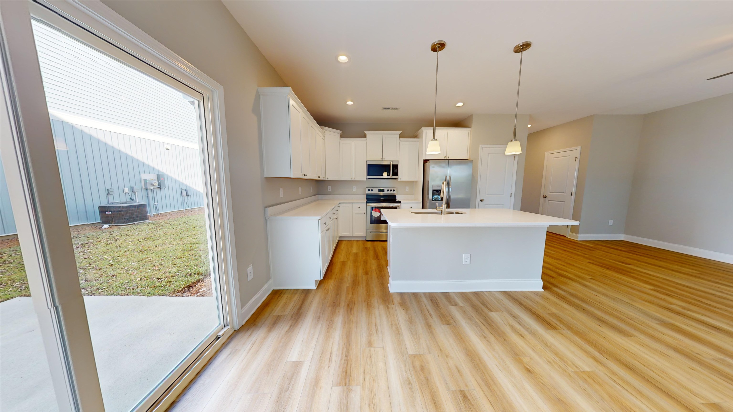 1032 Moen Loop, Unit LOT 9 Conway, SC 29526 - Photo 11 of 36 Kitchen with white cabinets, pendant lighting, stainless steel appliances, an island with sink, and light wood-style flooring