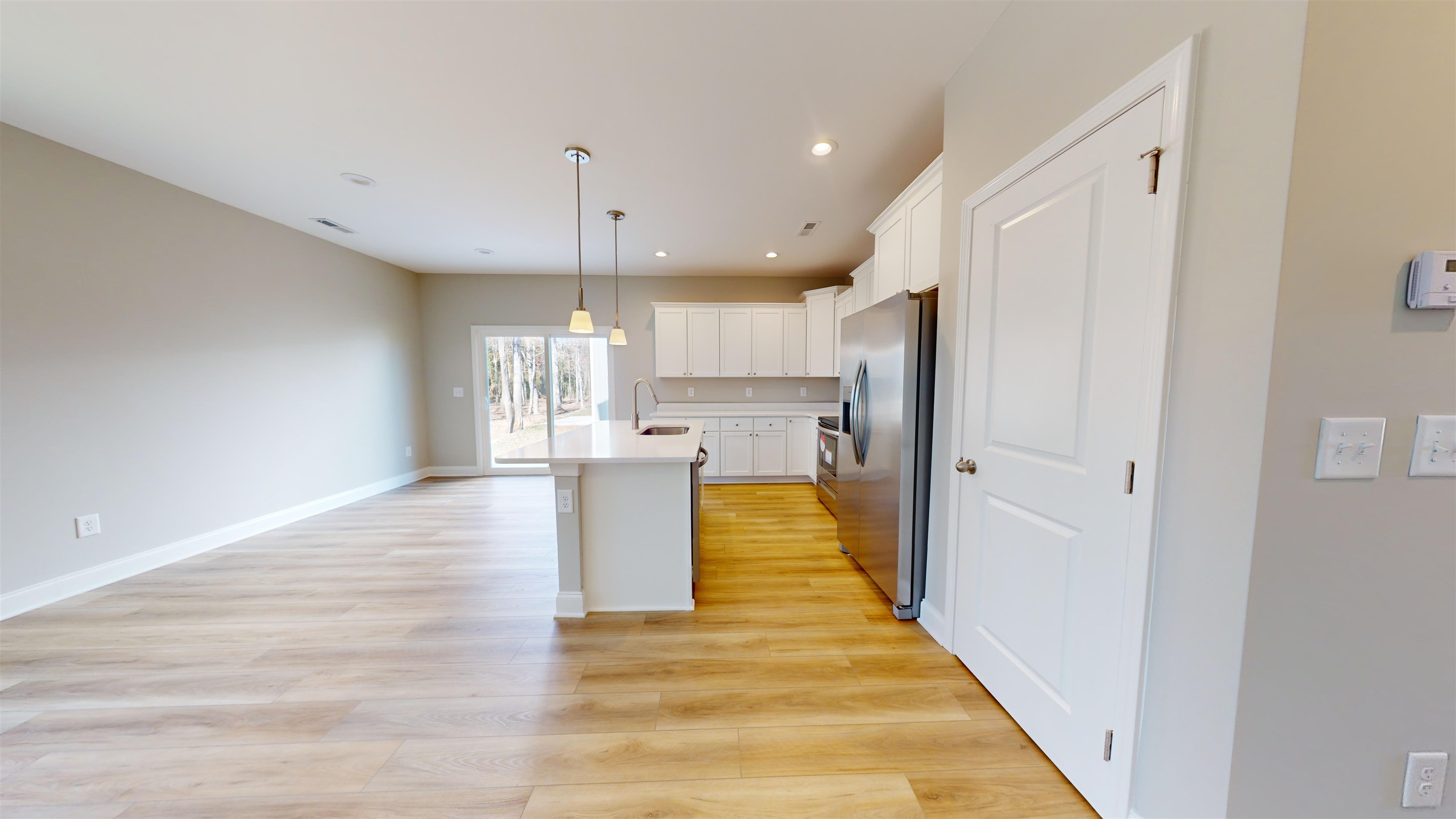 1032 Moen Loop, Unit LOT 9 Conway, SC 29526 - Photo 8 of 36 Kitchen with white cabinetry, appliances with stainless steel finishes, decorative light fixtures, light wood finished floors, and an island with sink
