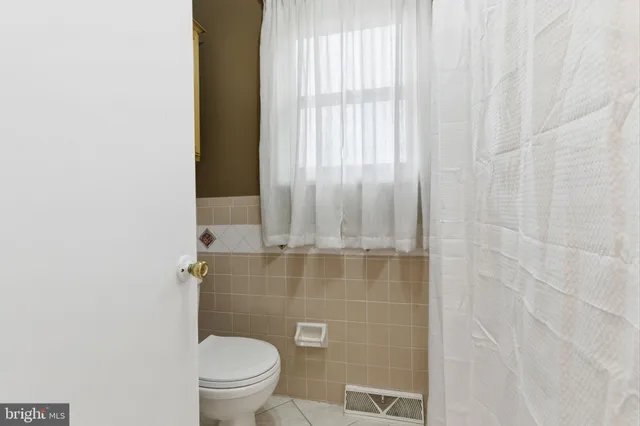 a bathroom with a granite countertop toilet and a sink