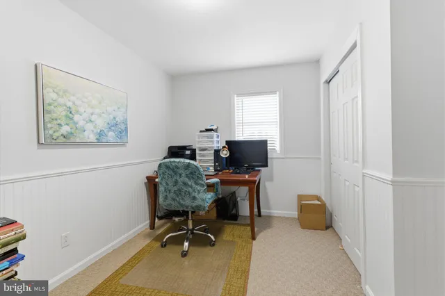a view of a workspace with furniture and a window
