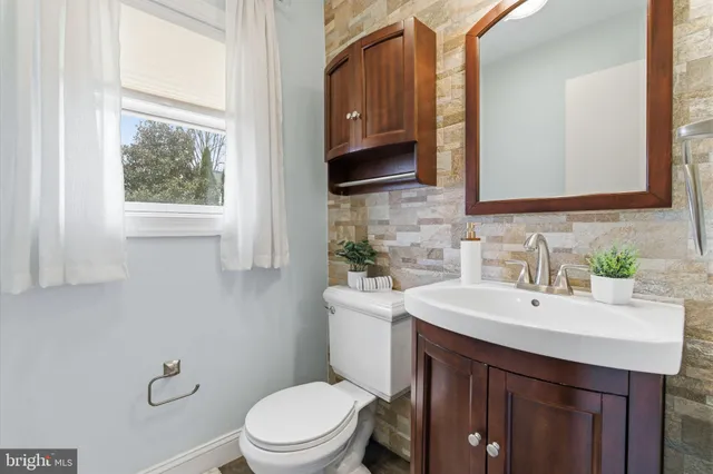 a bathroom with a sink a toilet and mirror
