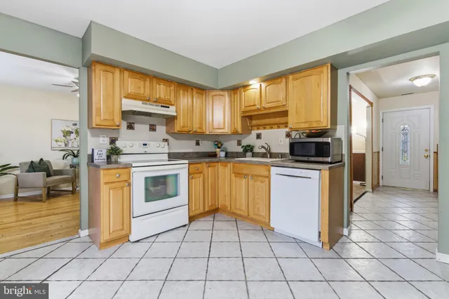 a kitchen with a stove a sink dishwasher a refrigerator and cabinets
