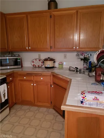 a kitchen with granite countertop a sink dishwasher stove and cabinets