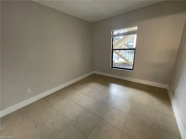 an empty room with entrance and windows