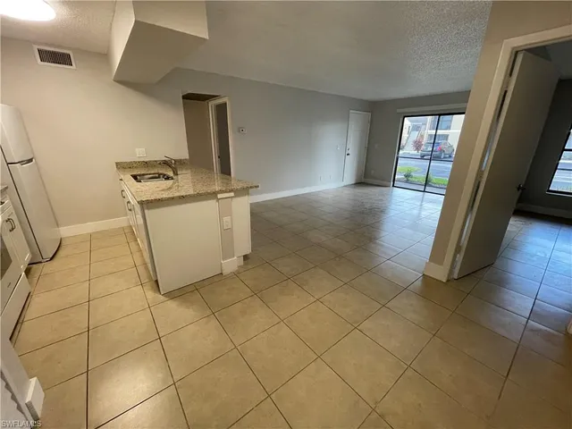 a view of a storage & utility room with fridge and wooden floor