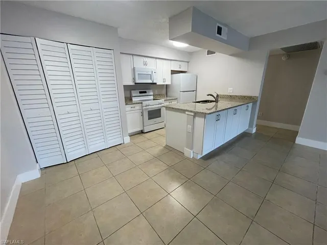 a kitchen with white cabinets and white appliances