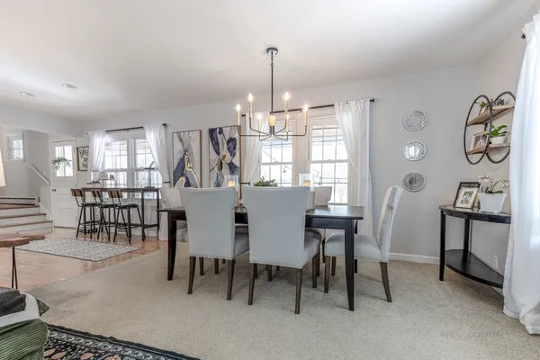 a view of a a dining room with furniture window and wooden floor
