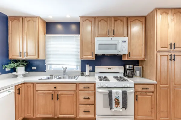 a kitchen with stainless steel appliances granite countertop a sink a stove and cabinets