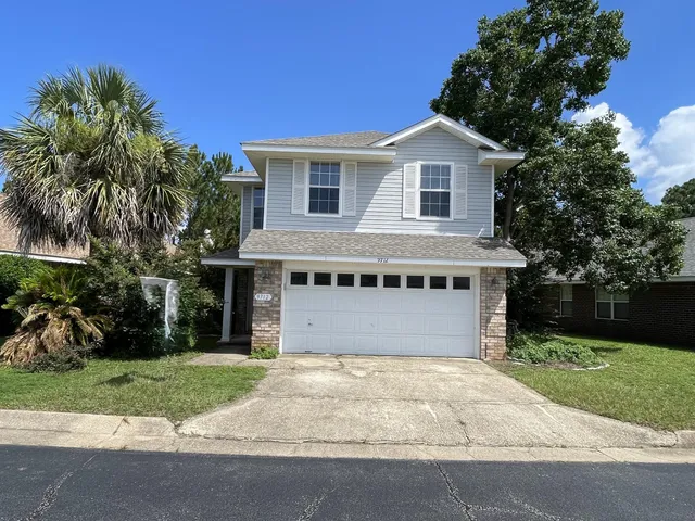 a view of a house with a yard and palm trees