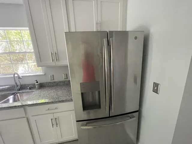 a kitchen with stainless steel appliances granite countertop a refrigerator and a sink