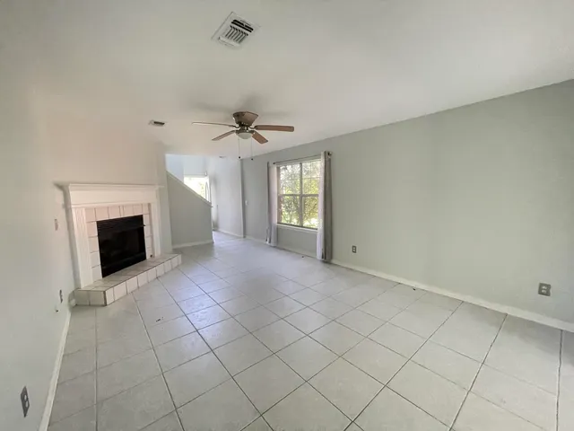 a view of an empty room with a fireplace and a window