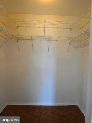 an empty room with chandelier fan and windows