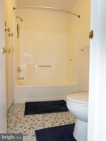 a bathroom with a granite countertop shower and a toilet