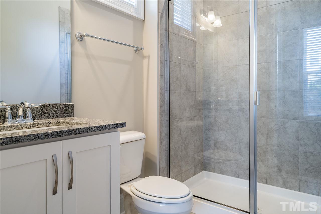 5928 Bellona Lane Raleigh, NC 27612 - Photo 15 of 25 a bathroom with a granite countertop sink toilet and shower