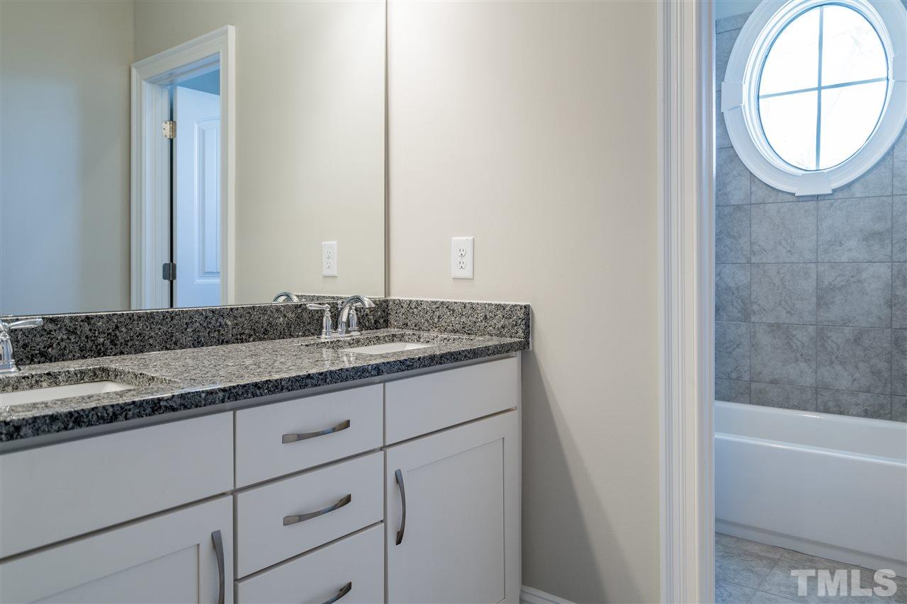 5928 Bellona Lane Raleigh, NC 27612 - Photo 22 of 25 a bathroom with a granite countertop sink and a mirror