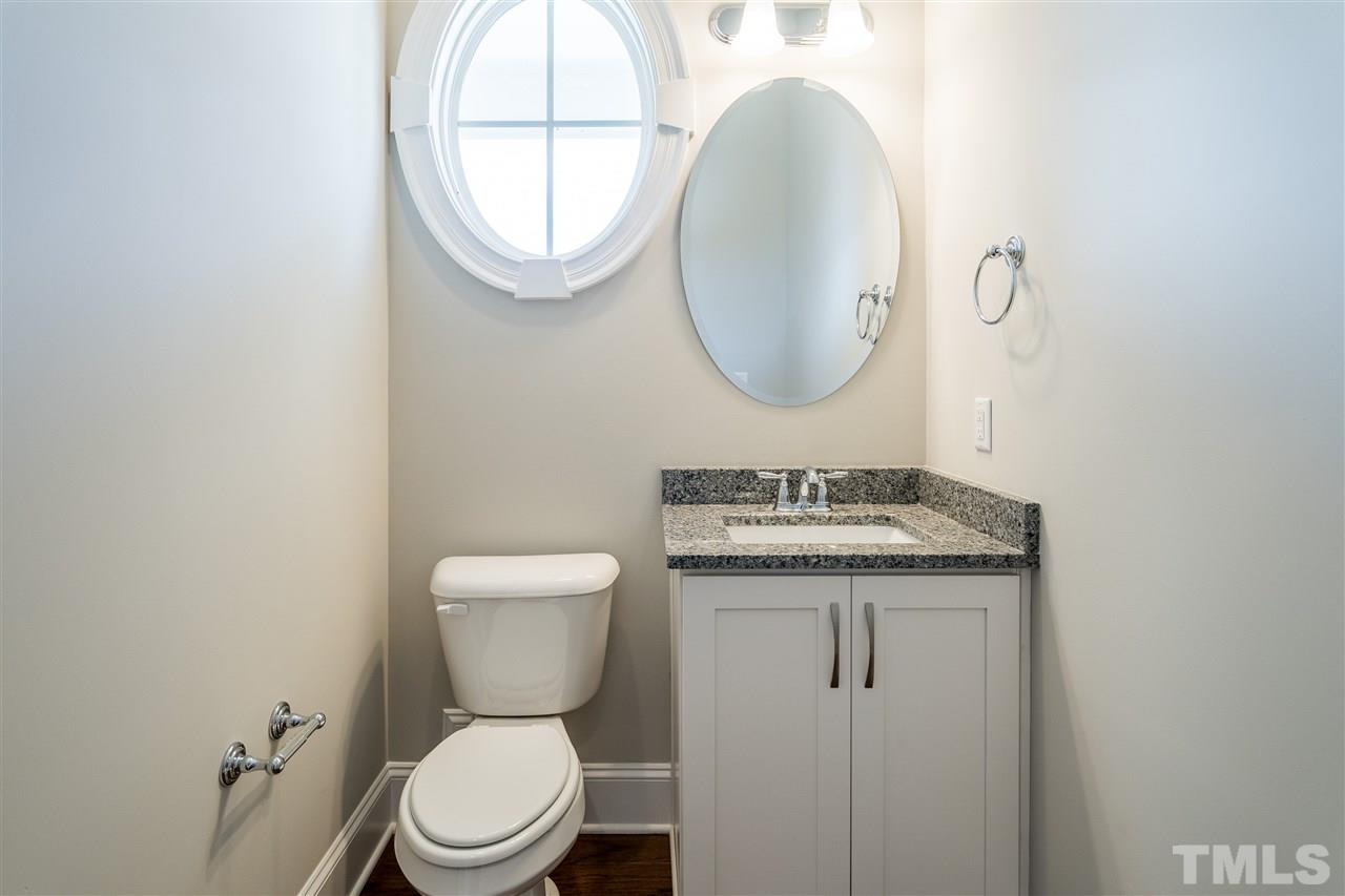 5928 Bellona Lane Raleigh, NC 27612 - Photo 5 of 25 a bathroom with a granite countertop toilet a sink and a mirror