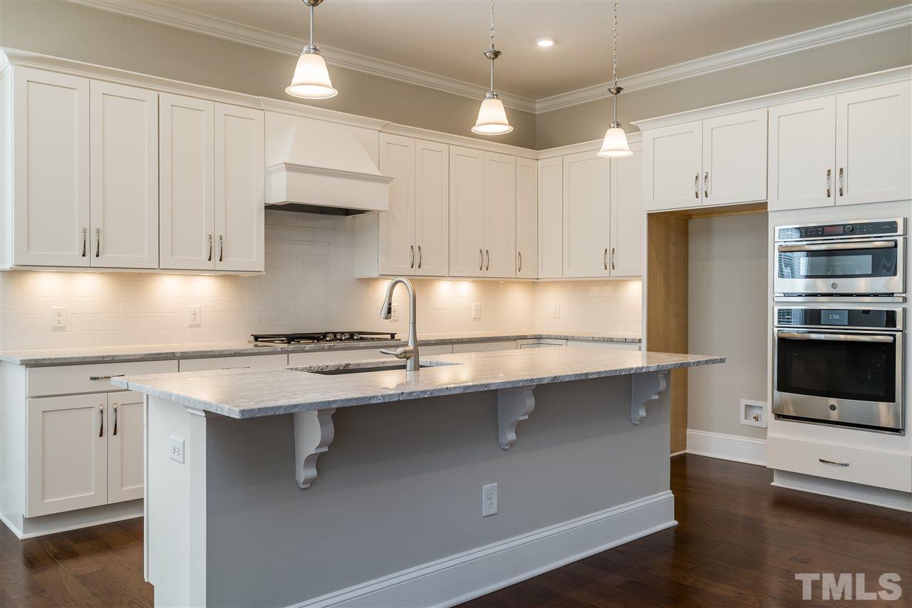 5928 Bellona Lane Raleigh, NC 27612 - Photo 7 of 25 a kitchen with stainless steel appliances granite countertop a sink stove and refrigerator