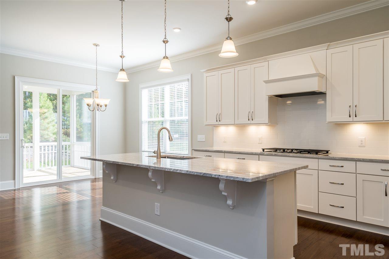 5928 Bellona Lane Raleigh, NC 27612 - Photo 8 of 25 a kitchen with stainless steel appliances granite countertop a sink a stove and white cabinets with wooden floor