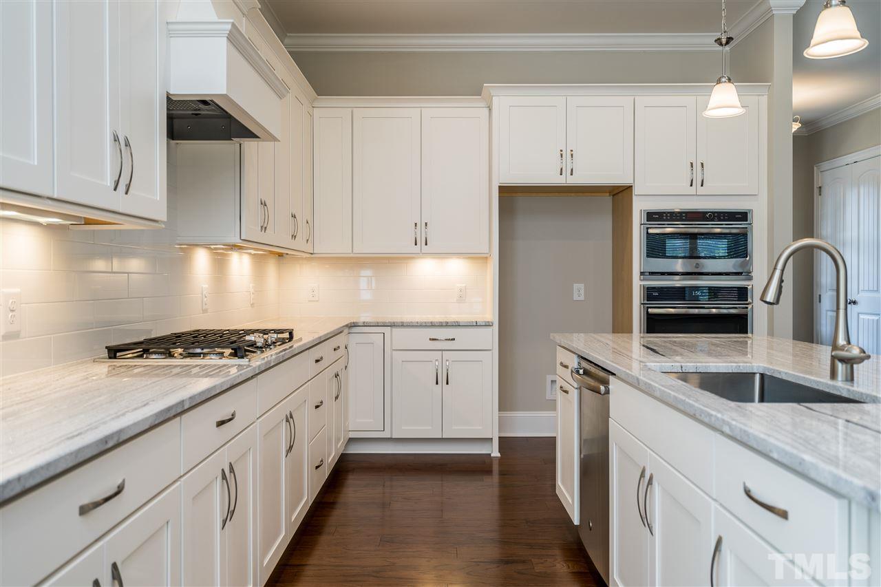 5928 Bellona Lane Raleigh, NC 27612 - Photo 9 of 25 a kitchen with granite countertop white cabinets and stainless steel appliances