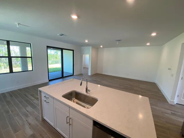 a kitchen with a sink and wooden floor
