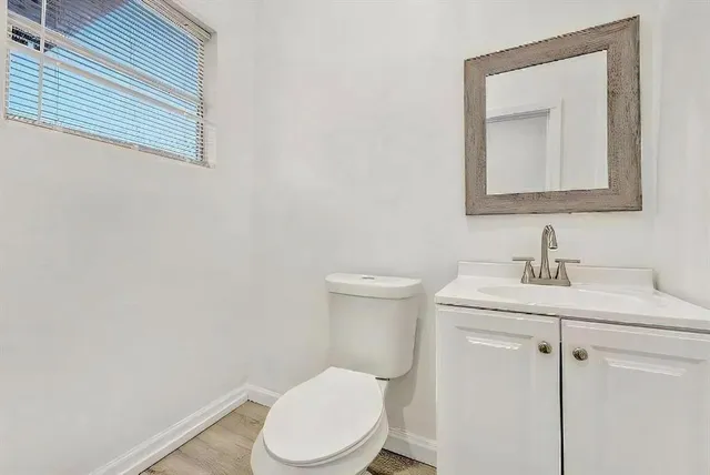 a bathroom with a toilet sink vanity and mirror