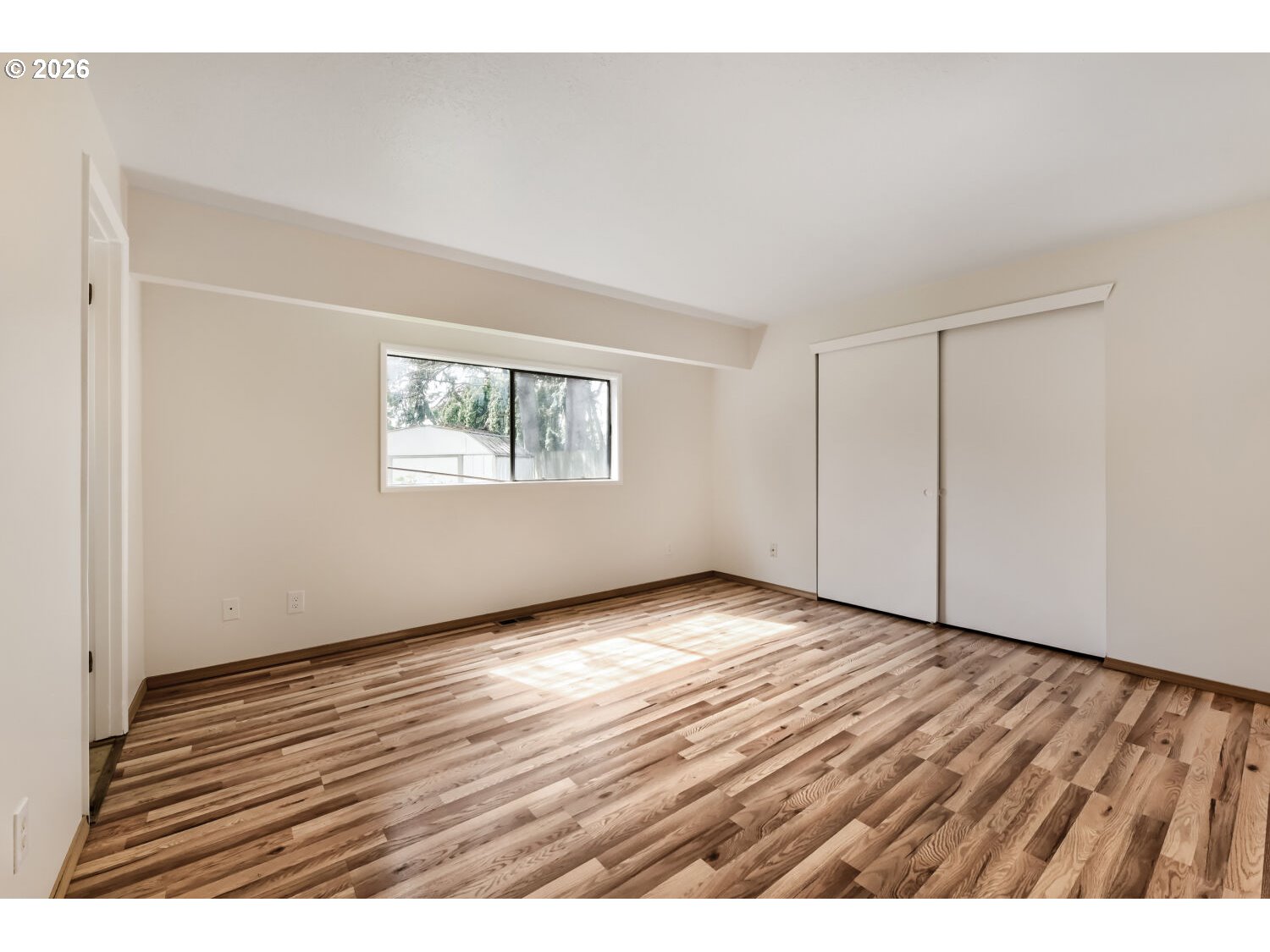 19710 Southwest Johnson Street Beaverton, OR 97003 - Photo 9 of 15 a view of an empty room with wooden floor and a window