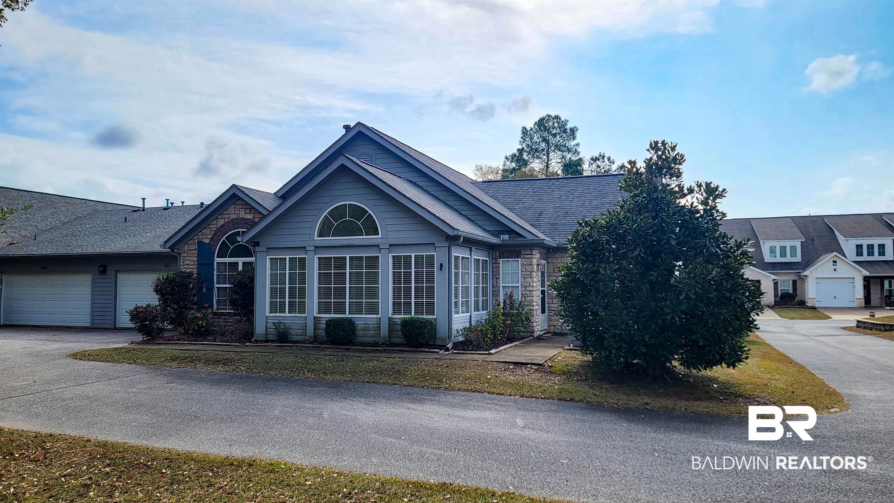 303 Wyld Palms Drive, Unit 303 Foley, AL 36535 - Photo 32 of 36 Single story home with stone siding, driveway, an attached garage, and roof with shingles